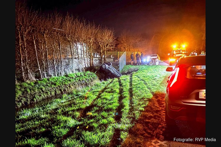 Auto met twee inzittenden te water langs Hornweg in Hem
