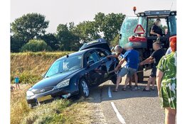 Spannende momenten voor inzittenden auto op de Zuiderdijk in Wijdenes, trekker haalt auto omhoog