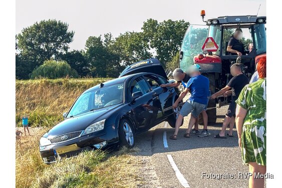 Spannende momenten voor inzittenden auto op de Zuiderdijk in Wijdenes, trekker haalt auto omhoog