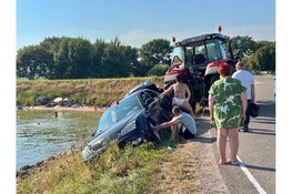 Spannende momenten voor inzittenden auto op de Zuiderdijk in Wijdenes, trekker haalt auto omhoog